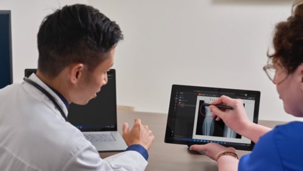 Ein Arzt Und Eine Krankenschwester Benutzen Gemeinsam Das Surface Pro 8 Mit LTE In Einem Krankenhaus